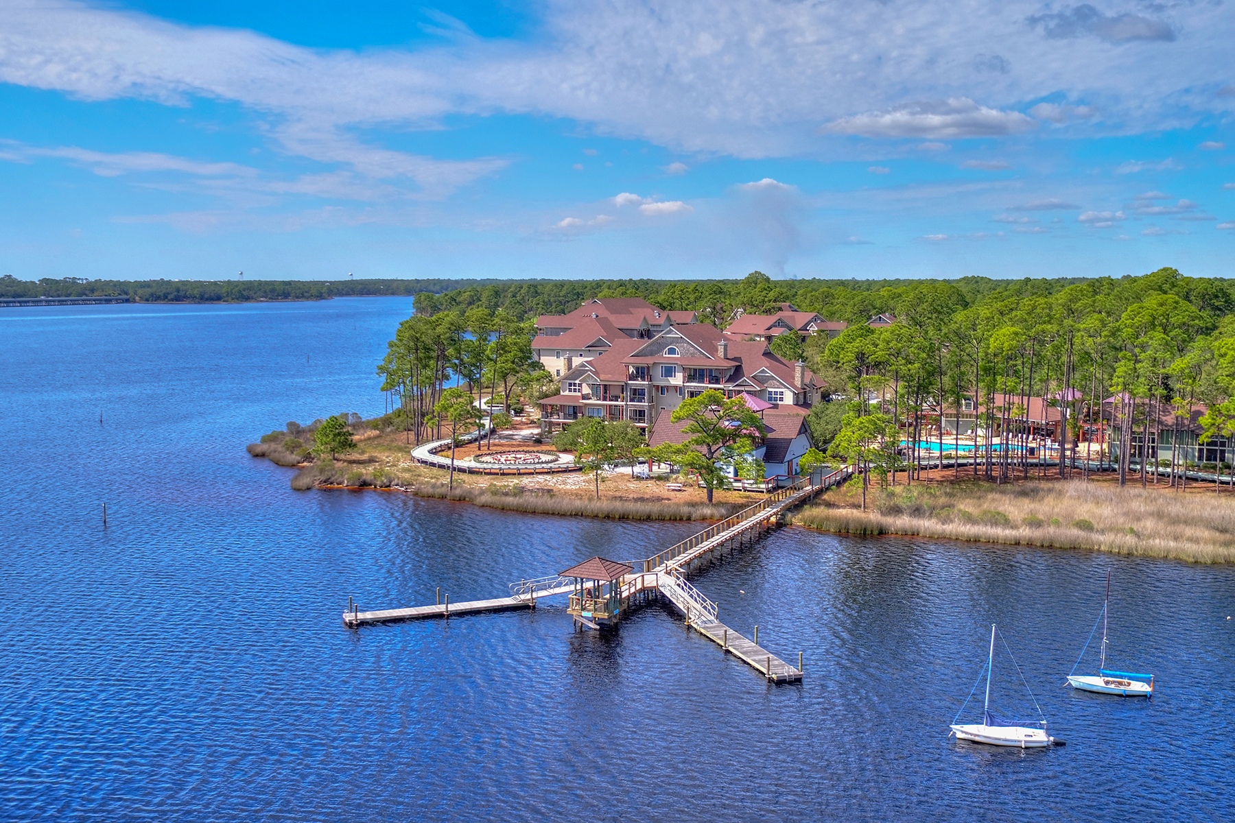 An aerial view of homes at Wild Heron showing a board walk over the lake